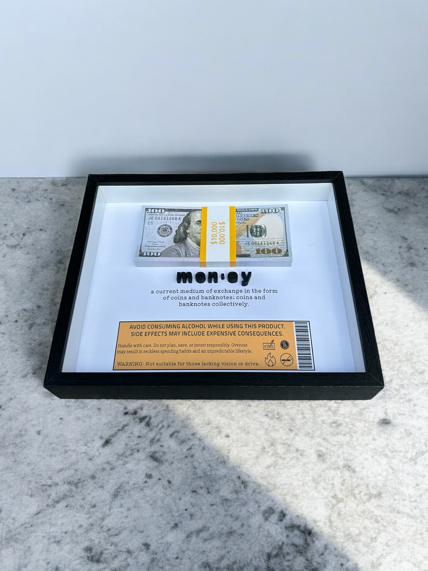 Handmade shadow box with the dictionary definition of money and prop bills
