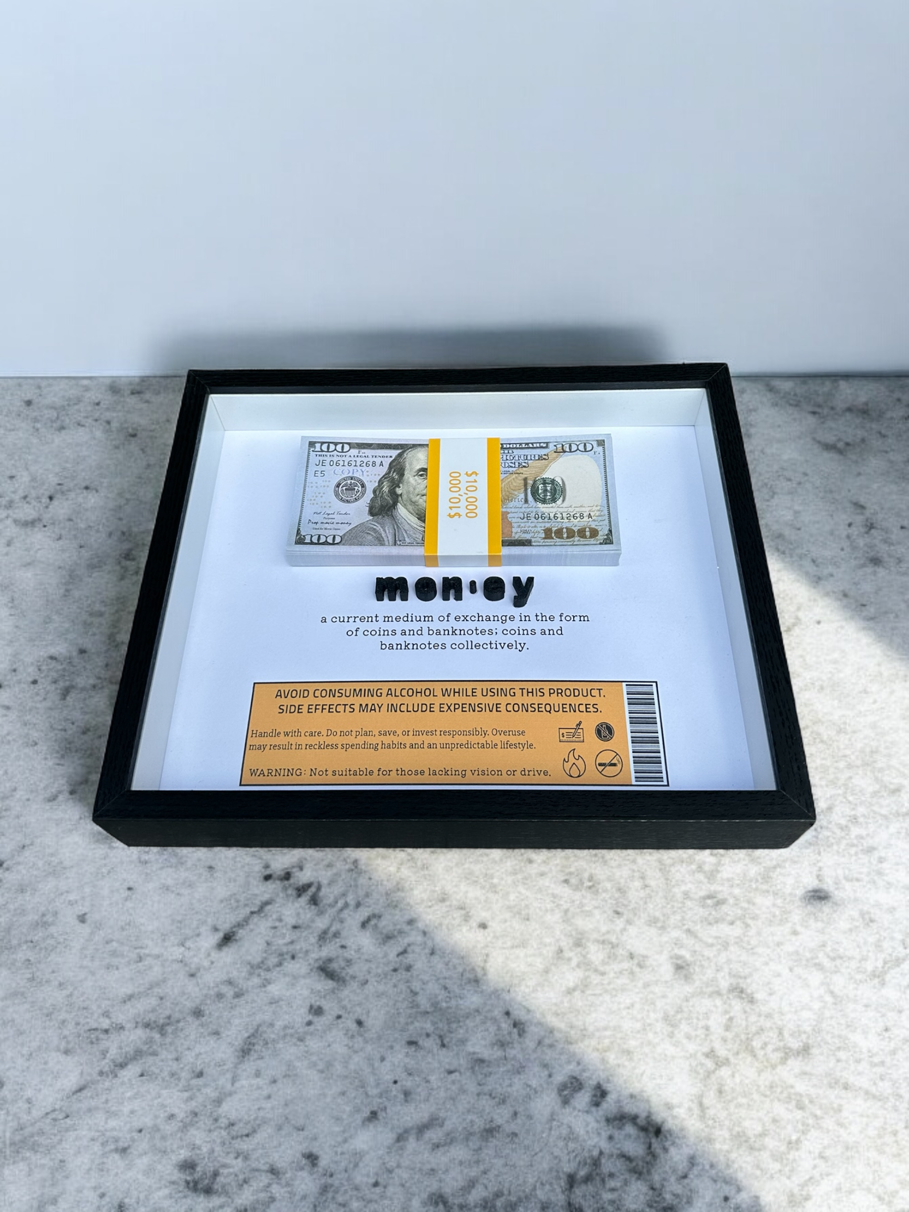 Handmade shadow box with the dictionary definition of money and prop bills