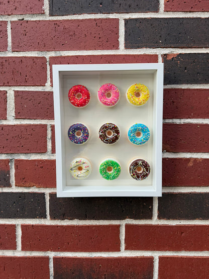 Handmade shadow box with a 3 by 3 grid of glossy hyper-real mini donuts