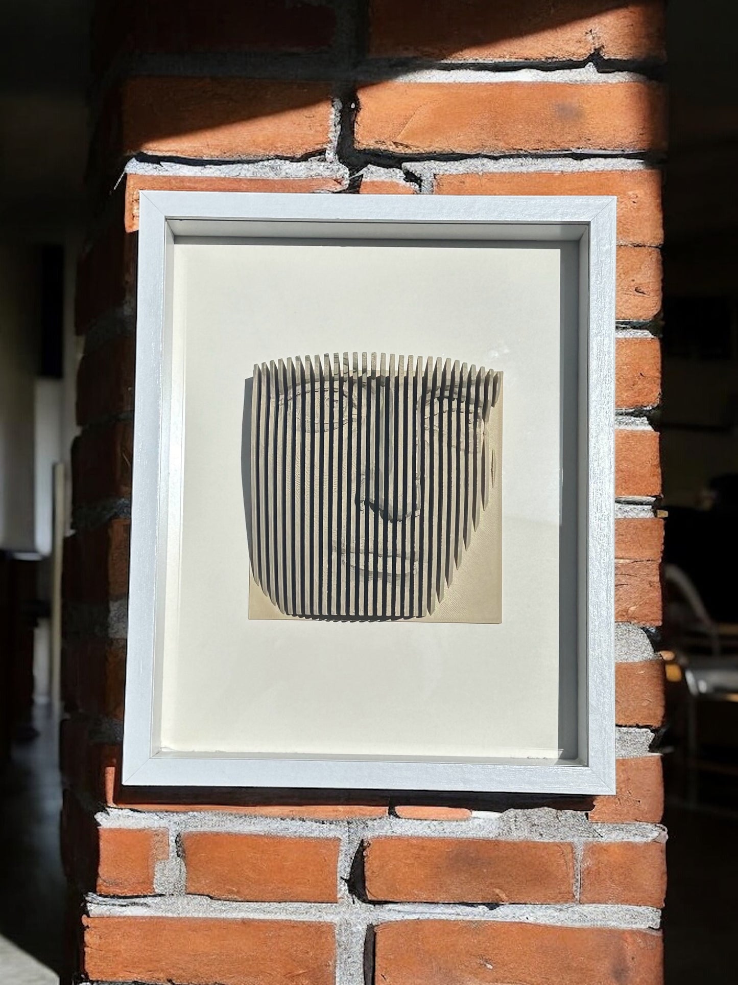 Handmade parametric shadow box of a face formed from fine vertical slats
